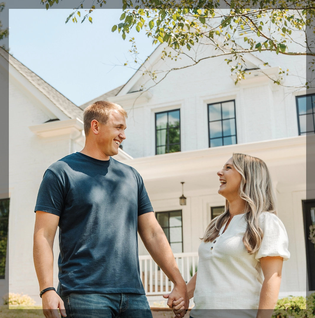 happy couple holding hands outside home