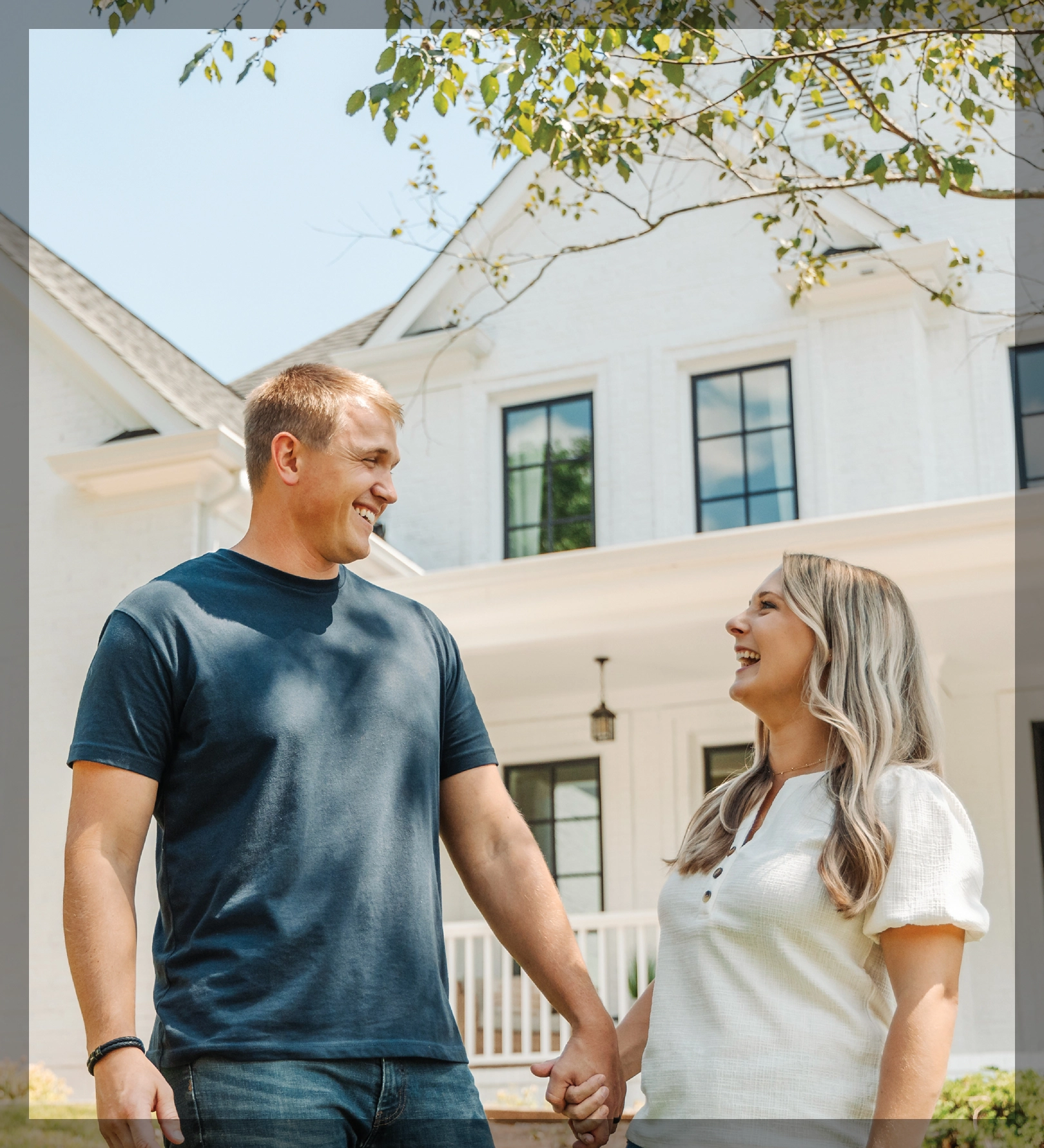 happy couple holding hands outside home